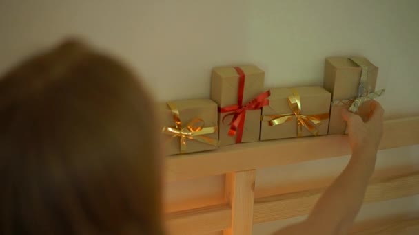 Slowmotion tiro de uma jovem mulher preparando um calendário edvent Natal — Vídeo de Stock