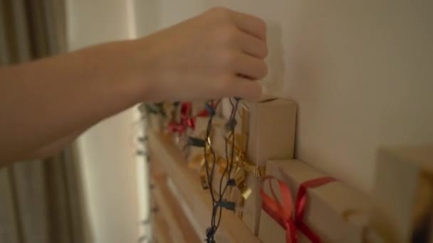 Closeup πλάνο του μια νεαρή γυναίκα που προετοιμάζει ένα Χριστουγεννιάτικο ημερολόγιο edvent — Αρχείο Βίντεο