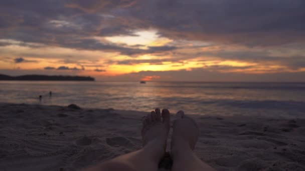 Nohy žena na pláži sledovat fantastický západ slunce — Stock video