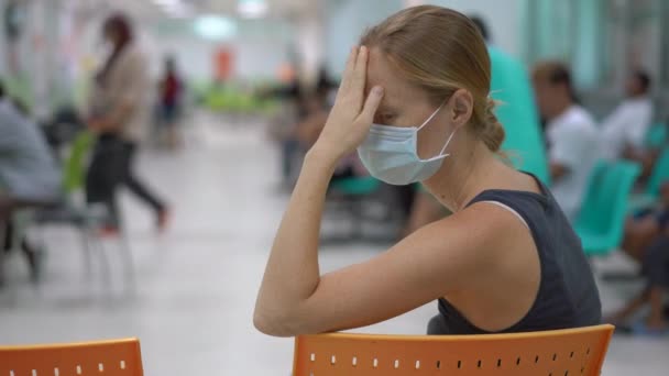 Doente jovem mulher sentada em um hospital à espera de consulta médica — Vídeo de Stock