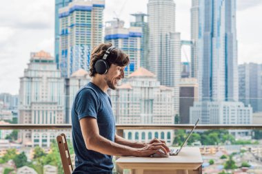 Genç adam bir yabancı dil öğreten ya da büyük bir şehir zemin karşı balkonunda internette yabancı dil öğrenir. Online dil okulu yaşam tarzı