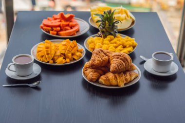 Kahvaltı masası zemin büyük şehrin karşı bir balkonda kahve meyve ve ekmek croisant ile