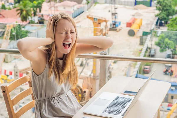 The girl works in a noise on the background of construction. Work in the noise concept — Stock Photo, Image