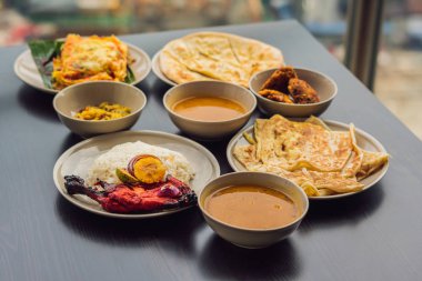 Koyu ahşap arka plan üzerinde çeşitli Hint yemeği. Yemekler ve mezeler Hint Mutfak. Köri, tereyağı tavuk, pirinç, mercimek, paneer, samosa, naan, Hint turşusu, baharatlar. Kase ve Hint yemekleri ile plakalar