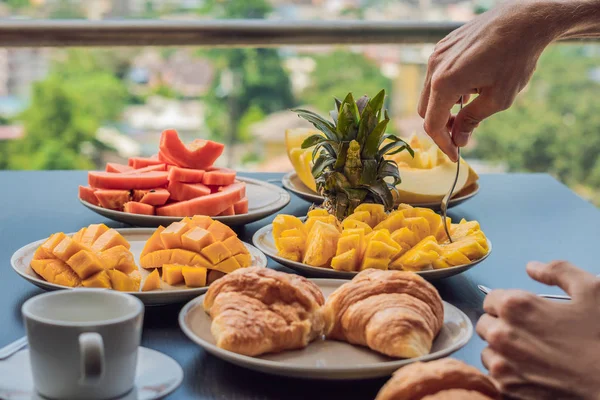 Mesa de pequeno-almoço com frutas de café e pão croisant em uma varanda contra o pano de fundo da cidade grande — Fotografia de Stock