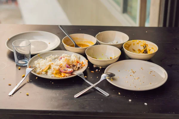 De resten van voedsel in platen, broodkruimels op tafel na de lunch of diner — Stockfoto
