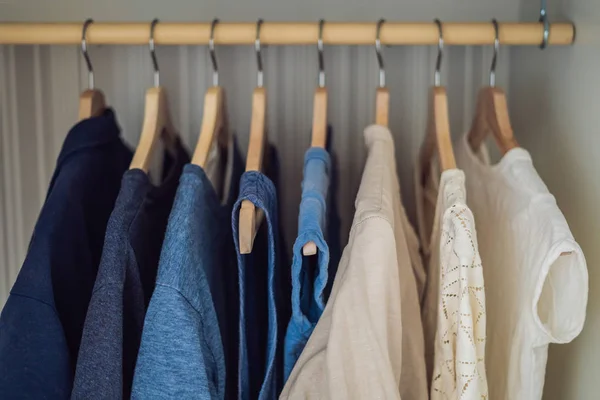 Одежда на вешалках в шкафу градиент от белого до темно-синего — стоковое фото