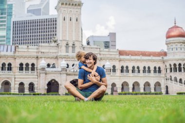 Baba ve oğul Merdeka Meydanı ve Sultan Abdul Samad Binası arka plan üzerinde. Çocuk kavramı ile seyahat