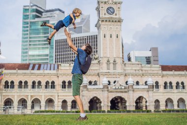 Baba ve oğul Merdeka Meydanı ve Sultan Abdul Samad Binası arka plan üzerinde. Çocuk kavramı ile seyahat