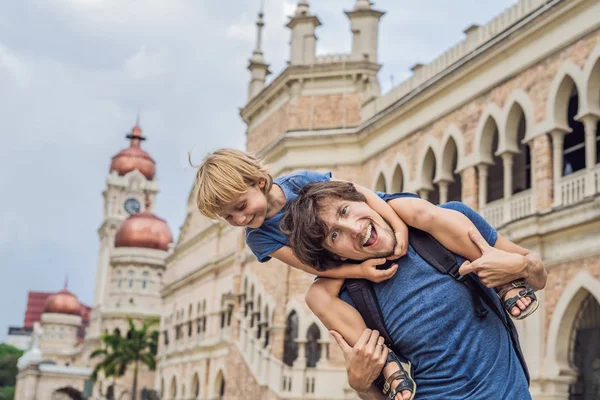 Táta a syn na pozadí Sultan Abdul Samad Building v Kuala Lumpur, Malajsie. Cestování s dětmi koncepcí — Stock fotografie