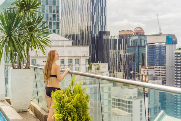 Young woman in the pool among the skyscrapers and the big city. Relax in the big city. Rest from stress — Stock Photo, Image