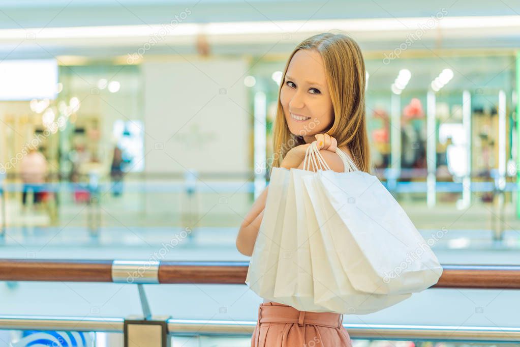Women carrying a lot of shopping bags in blurred shopping mall
