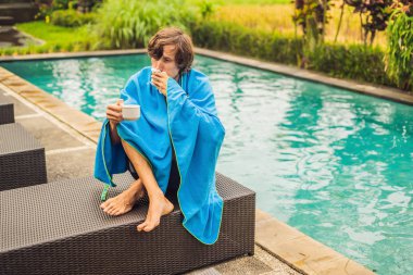 Hasta bir adam gezgin. Adam tatilde üşütmüş, çay içme havuzda üzgün oturur ve burnunu içine bir peçete darbeler. Oğlu sağlıklı ve yüzme havuzunda. Seyahat sigortası kavramı