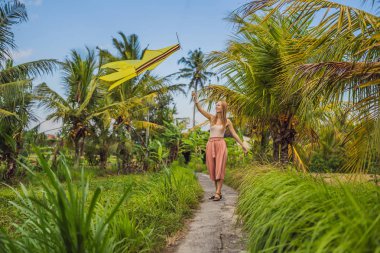 Genç kadın bir pirinç alan Ubud, Bali Adası, Endonezya uçurtma başlattı