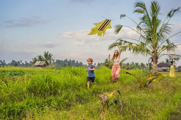 Мама и сын запускают воздушного змея на рисовом поле в Убуде, остров Бали, Индонезия — стоковое фото