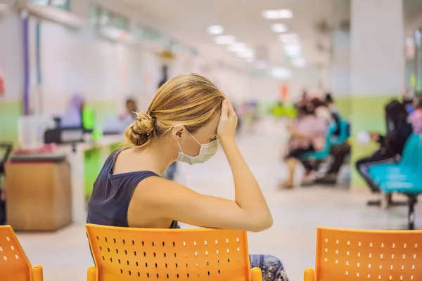 Une jeune femme assise à l'hôpital attendant un rendez-vous chez le médecin. Patients dans la salle d'attente des médecins — Photo