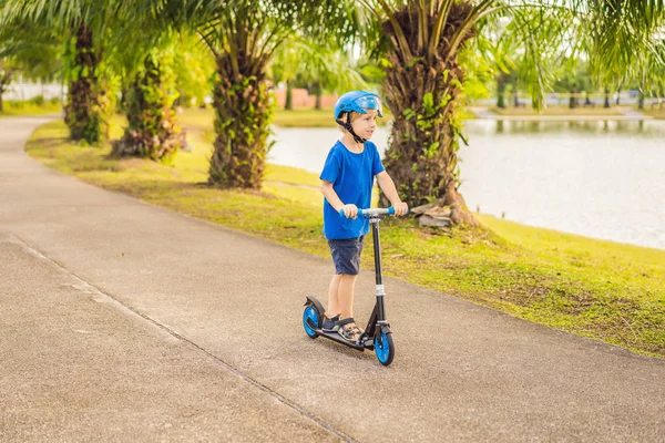 Jongen rijden van scooters, buiten in het park, zomer. Kinderen zijn blij buiten spelen — Stockfoto