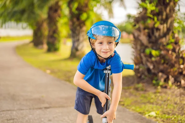 Мальчик на скутерах, на открытом воздухе в парке, летом. Дети счастливы играть на свежем воздухе — стоковое фото