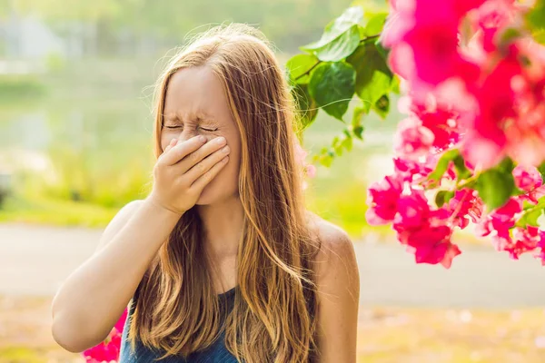 Jovem mulher bonita soprando nariz na frente da árvore florescente. Conceito de alergia Primavera — Fotografia de Stock