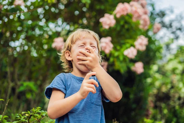 Băiatul suflă nasul în faţa copacului înflorit. Conceptul de alergie de primăvară. Alergii la copii — Fotografie, imagine de stoc