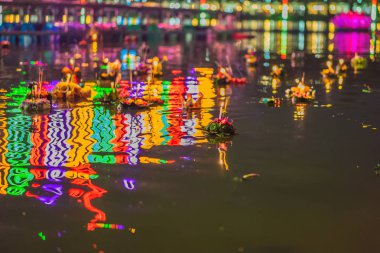 Loy Krathong festivali. İnsanlar Tayland 'daki Loy Krathong festivalini kutlamak için çiçek ve mum alıp suyun üzerinde yüzüyor.
