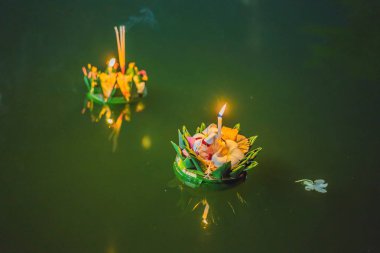 Loy Krathong festivali. İnsanlar Tayland 'daki Loy Krathong festivalini kutlamak için çiçek ve mum alıp suyun üzerinde yüzüyor.