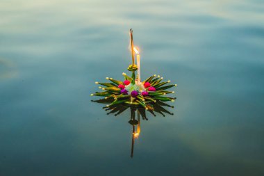 Loy Krathong festivali. İnsanlar Tayland 'daki Loy Krathong festivalini kutlamak için çiçek ve mum alıp suyun üzerinde yüzüyor.