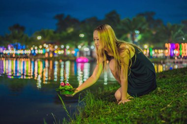 Genç kadın Loy Krathong, su üzerinde çalışan kutluyor. İnsanlar çiçek ve mum yakıp Tayland Loy Krathong Festivali kutlamak için su üzerinde yüzer Loy Krathong Festivali, satın