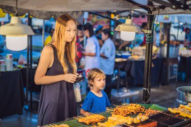 Anne ve oğlu turist street yürüyüş Asya gıda pazarında vardır