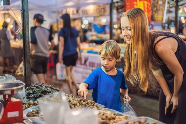 Anne ve oğlu turist street yürüyüş Asya gıda pazarında vardır