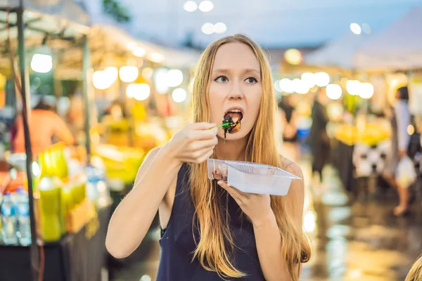 Jonge vrouw toeristische Walking street Aziatisch eten brengen — Stockfoto