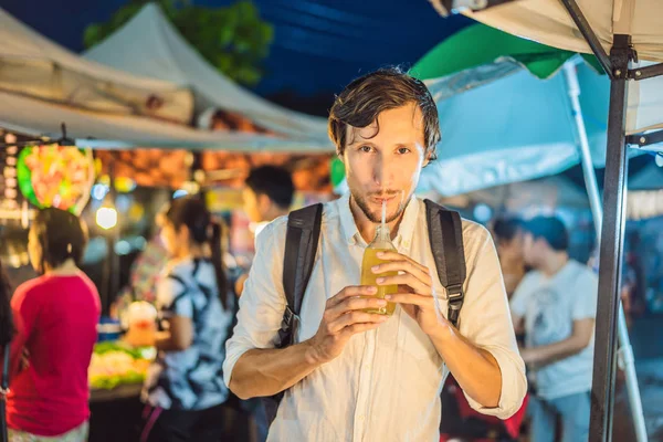 Man drinking sugar cane juice on the Asian market — Stock Photo, Image