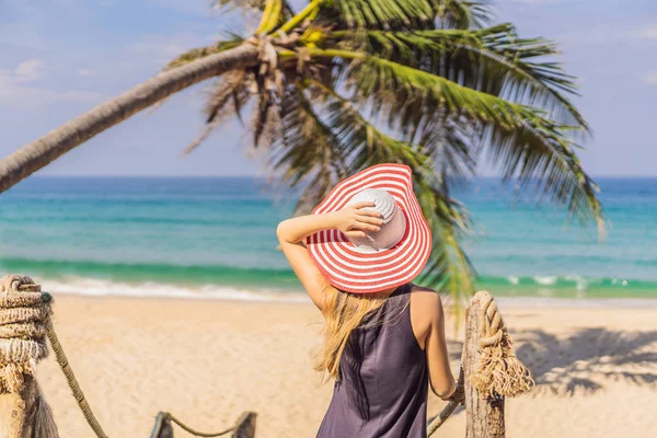 Vacanza sull'isola tropicale. Donna in cappello godendo della vista sul mare dal ponte di legno — Foto Stock