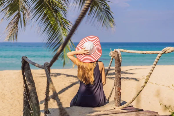 Διακοπές σε τροπικό νησί. Γυναίκα με καπέλο, απολαμβάνοντας τη θέα στη θάλασσα από το ξύλινο γεφυράκι — Φωτογραφία Αρχείου