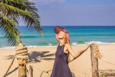 Tatil tropikal adada. Deniz manzarayı ahşap köprü şapkalı kadın