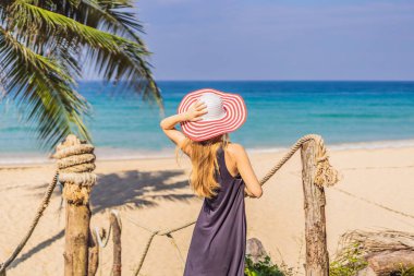 Tatil tropikal adada. Deniz manzarayı ahşap köprü şapkalı kadın