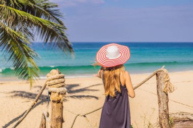 Tatil tropikal adada. Deniz manzarayı ahşap köprü şapkalı kadın
