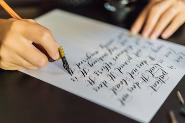 Hattat eller yazar ifade beyaz kağıt üzerinde. Aşk Inscribing süs süslü harfler hakkında İncil ifade. Hat sanatı hocası, grafik tasarım, harfler, el yazısı, yaratma kavramı