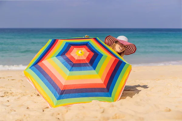 Giovane donna in spiaggia con cappello e ombrellone — Foto Stock