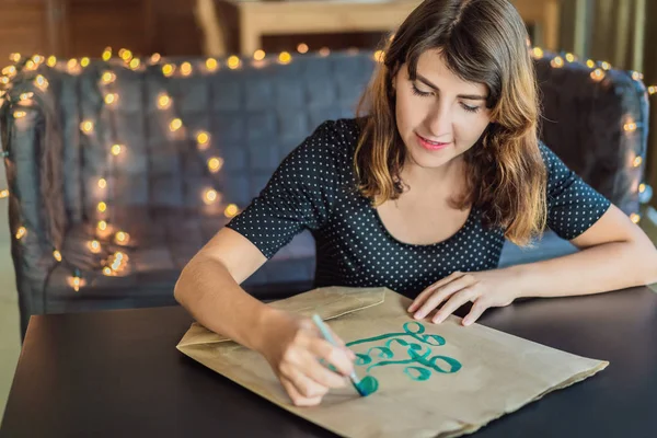 Kalligráfus fiatal nő fehér papírra írja a kifejezést. Megy zöld. Díszes, díszített betűk inscribing. Kalligráfia, grafikai tervezés, betűk, kézírás, fogalom alkotás — Stock Fotó