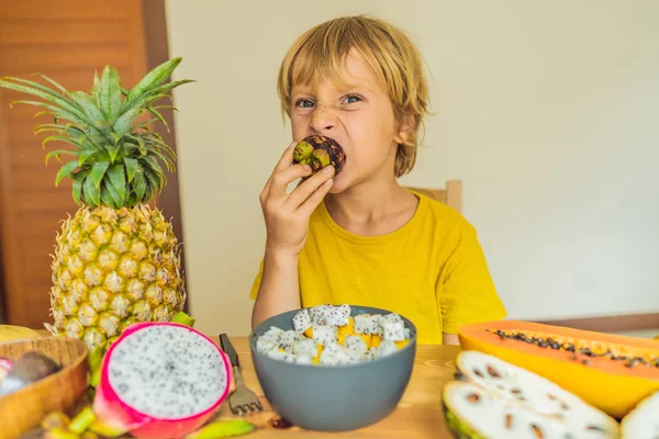 El chico come fruta. Comida saludable para niños. Niño comiendo bocadillos saludables. Nutrición vegetariana para niños. Vitaminas para niños — Foto de Stock