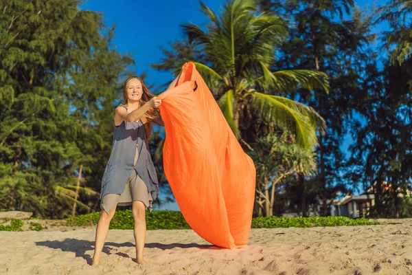 在热带岛屿的海滩上, 妇女的夏季生活方式肖像充气橙色沙发。在空气床上放松和享受生活 — 图库照片