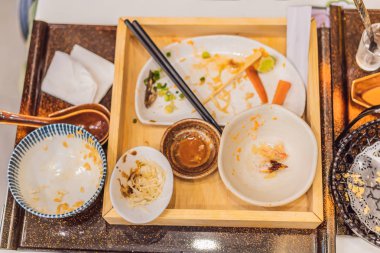 Japon restoranında yemekten sonra dağınık bir masa. Pis yemek, yemek artıkları, konseptler.