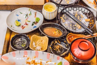 Japon restoranında yemekten sonra dağınık bir masa. Pis yemek, yemek artıkları, konseptler.