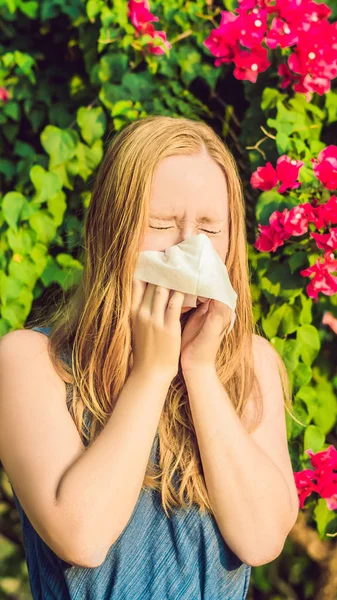 Młode ładne kobiety dmuchanie nosa przed kwitnące drzewo. Wiosną alergii koncepcja Format pionowy dla wątku mobilnej Instagram lub rozmiar historie. Wersja na telefon — Zdjęcie stockowe