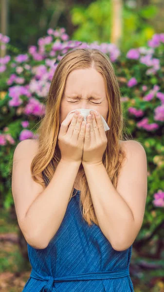 Ung söt kvinna blåser näsan framför blommande träd. Våren allergi koncept vertikala Format för Instagram mobila berättelse eller berättelser storlek. Mobila tapeter — Stockfoto