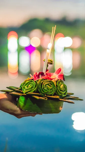 Mladá žena slaví Loy Krathong, běží na vodě. Loy Krathong festival, lidé kupují květiny a svíčky světlo a plovoucí na vodě na oslavu Loy Krathong festival v Thajsku vertikální — Stock fotografie