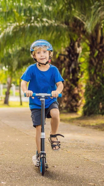 Kluk na motorce, venku v parku, léto. Děti jsou šťastné hraní venku vertikální formát pro Instagram mobilní příběh nebo příběhy velikosti. Mobilní tapety — Stock fotografie