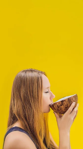 Ung kvinna dricka kokosmjölk på Chafrom kokos på en gul bakgrund vertikala Format för Instagram mobila berättelse eller berättelser storlek. Mobila tapeter — Stockfoto