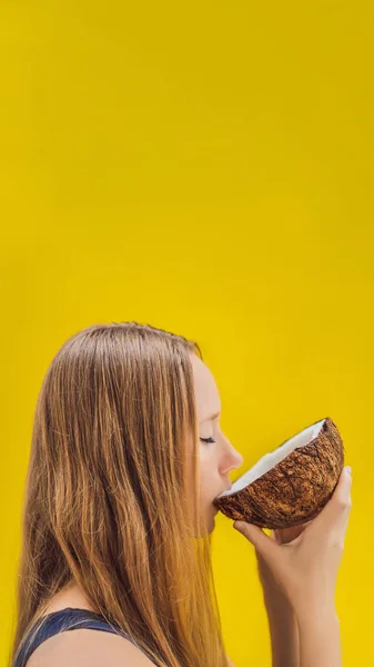Young woman drinking coconut milk on Chafrom coconut on a yellow background VERTICAL FORMAT for Instagram mobile story or stories size. Mobile wallpaper — Stock Photo, Image